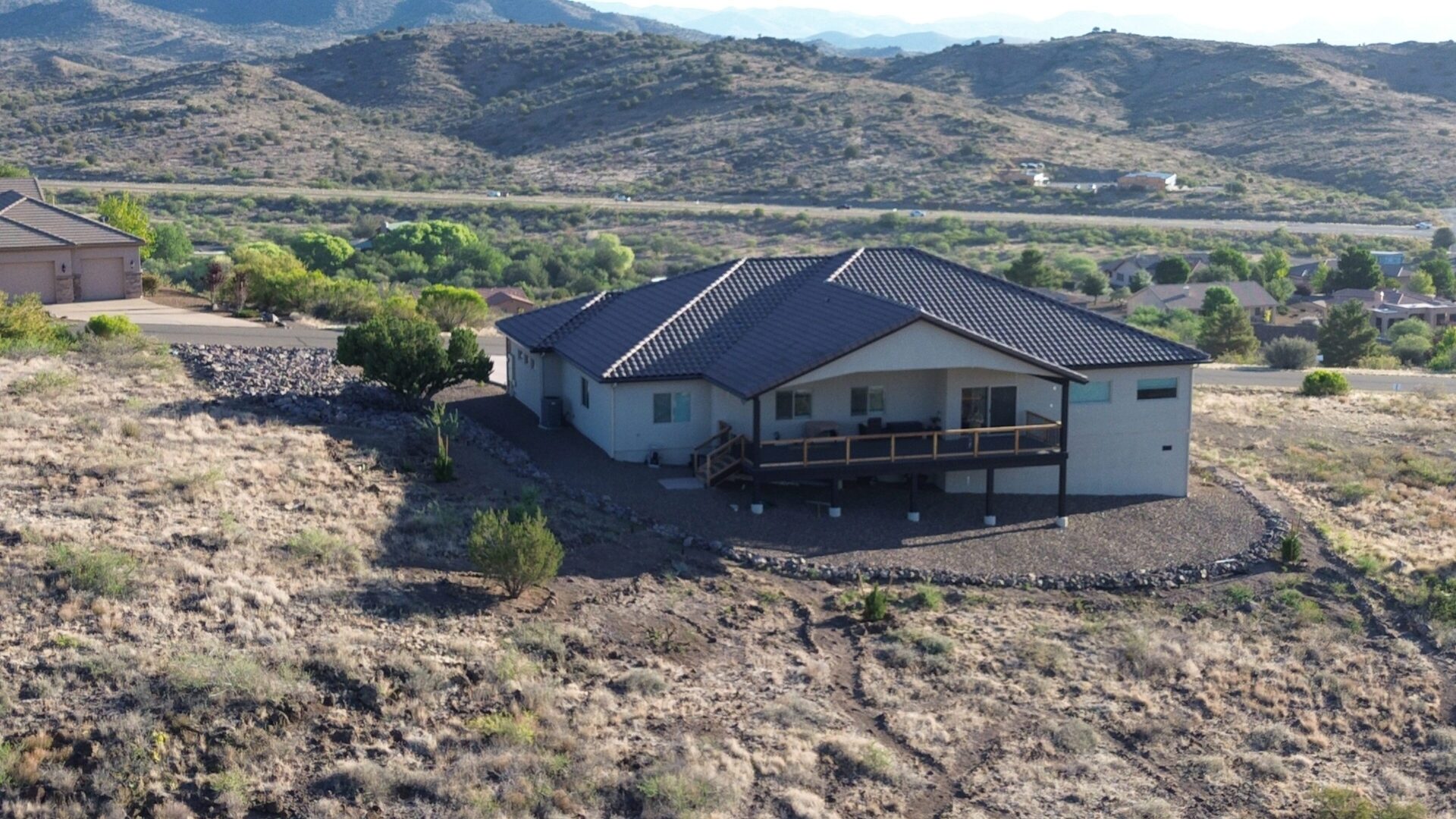 House on a hillside overlooking a valley with mountains in the distance.